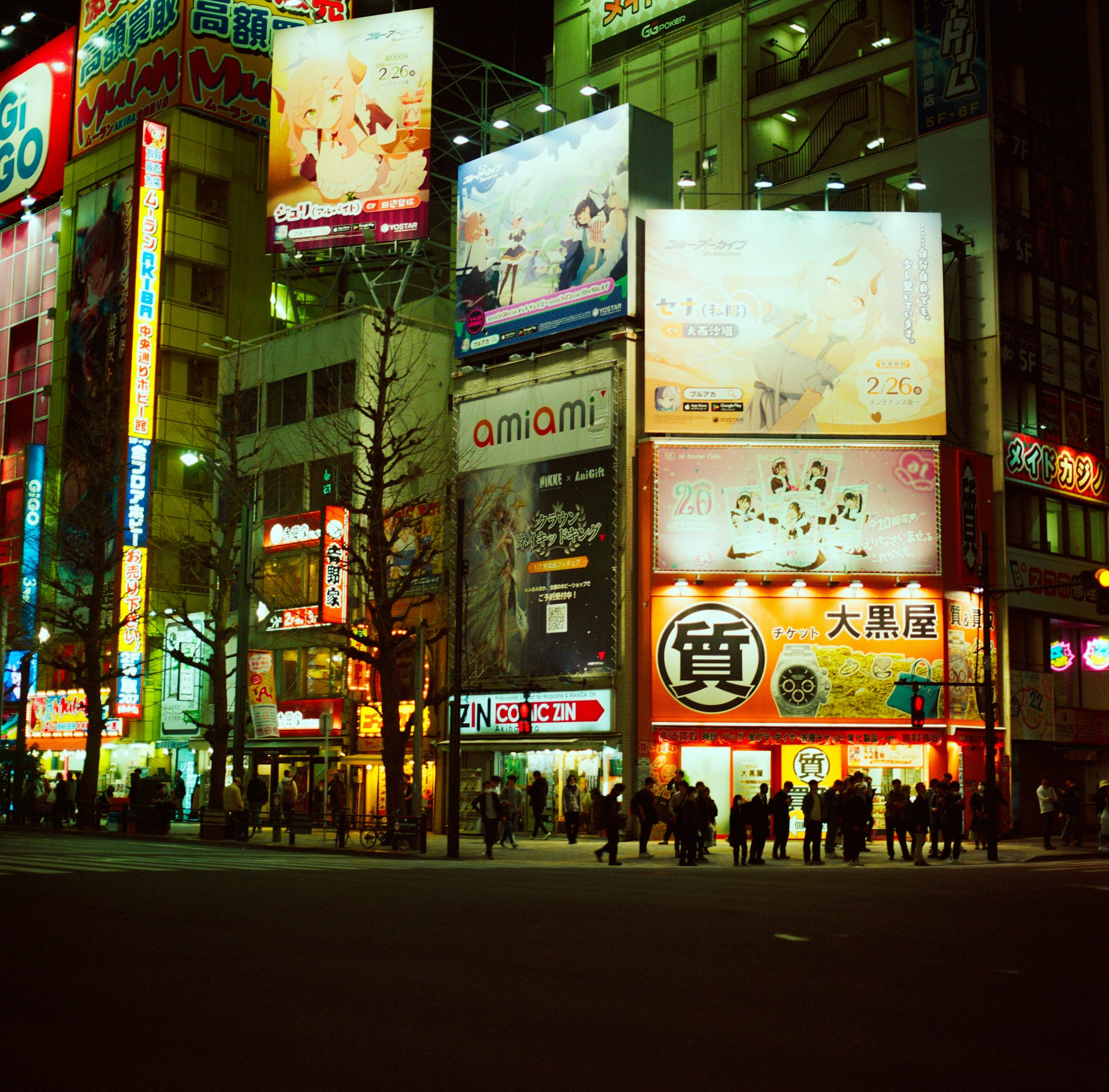Bright neon signs light up a busy tokyo street.